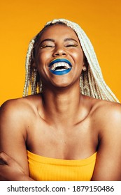 Close Up Of Laughing Woman On Yellow Background. Portrait Of African American Woman Having Braided Hair Laughing With Closed Eyes.