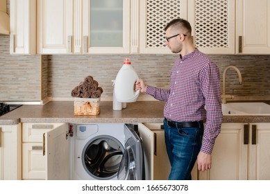 Close up a laundry basket full with fresh clean towels near a young man that hold bottle of liquid detergent powder wash, bleach, spray on vintage stone background. - Powered by Shutterstock