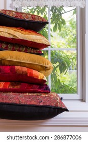 Close up Layered Authentic Squared Pillows In Front of Glass Window Inside the House.
