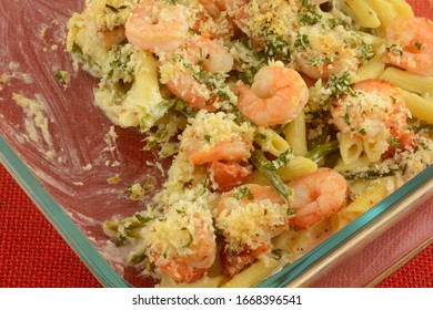 Close Up Of Leftovers Of Shrimp, Pasta, Tomato And Asparagus Casserole In Glass Baking Pan