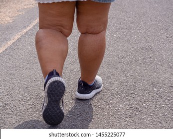Close up leg fat women running shoes is walking on the street alone.