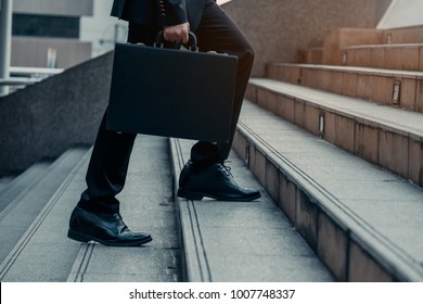 Close Up Legs Of Businessman Walks With His Briefcase Up Stair In Modern City, Business Growth, Success, Grow Up. Business Concept.