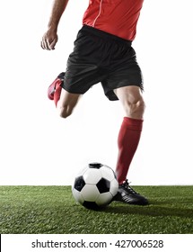 close up legs of football player in red socks and black shoes running and kicking the ball in free kick action playing isolated on white background