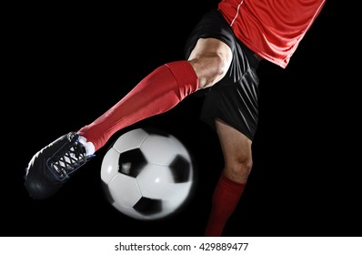 Close Up Legs And Soccer Shoe Of Football Player In Action Kicking Ball Isolated On Black Background Wearing Red Jersey And Sock