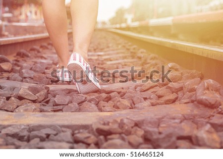 Close up legs of woman walking in railway. Vintage filter effect