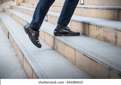 Close Up Legs Of Young Asian Businessman Walking Upstairs Outside Office In The City , Business Concept Copy Space. Feet Of Traveling Man In Leather Black Shoes.