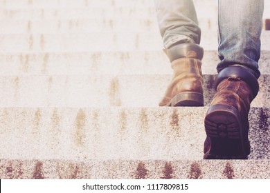 Close Up Legs Of Young Hipster Man One Person Walking Stepping Going Up The Stairs In Modern City,  Go Up, Success, Grow Up. With Filter Tones Retro Vintage Warm Effect.