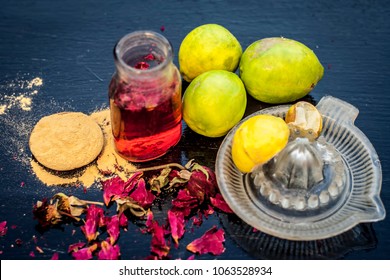 Close Up Of Lemon Face Pack With All Its Ingredients I.e. Rose Water, Lemon Juice, Fuller’s Earth On Black Wooden Surface.