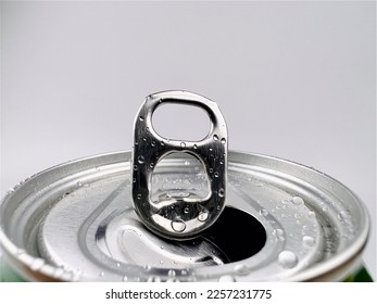 Close up Lid opens soft drink cans and drops of water.