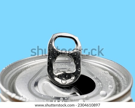 Close up Lid opens soft drink cans and drops of water on blue background 