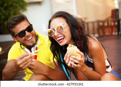 Close Up Lifestyle Funny Portrait Of Couple Laughing And Having Fun Together,funny Date With Burgers And French Fry,funny Mood And Crazy Emotions,man Joke Of Her Girlfriend,feed Her And Shows Tongue