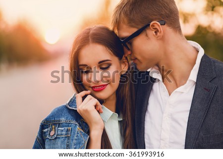 Close up lifestyle  toned image of young couple in love hugging. . Pretty young girl in jeans  jacket  and her handsome boyfriend  dating. Romantic mood. 