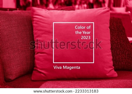 Close up light fabric sofa with warm cozy cushions with home interior background. Image toned in trendy pantone color of year 2023 Viva Magenta. Pink pillow on sofa room decoration background