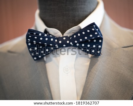 Close up of light grey jacket with bow