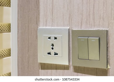 Close Up Of  Light Switch Outlet. Electric Plug And Switches On Wall In Living Room, Electric Concept. Switch And Plug On Wooden Wall.