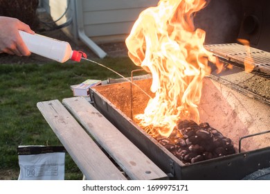 Close Up Of Lighter Fluid Being Squirted On Bbq