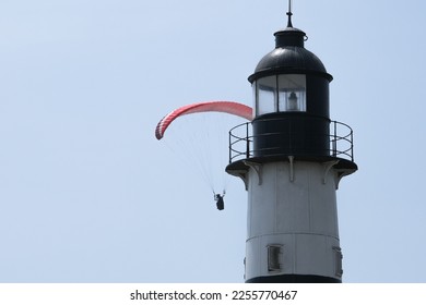 Close up lighthouse and paraglider  in Miraflores Lima Peru. Person is paragliding in Miraflores Lima Peru with lighthouse. Selective focus. Open space area.	 - Shutterstock ID 2255770467