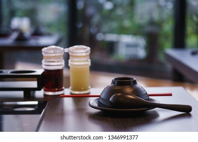 Close up lime and shoyu sauce bottle with dish and spoon on shabu shabu table.
