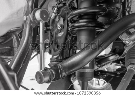 Close up Link stabilizer front mounted under the suspension of the car black and white