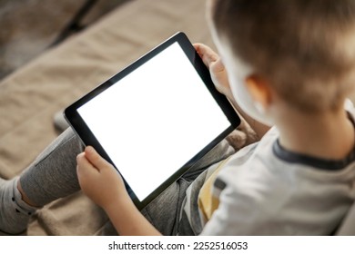 Close up of a little boy living unhealthy life in computer era. A boy is wasting his time with tablet. - Powered by Shutterstock