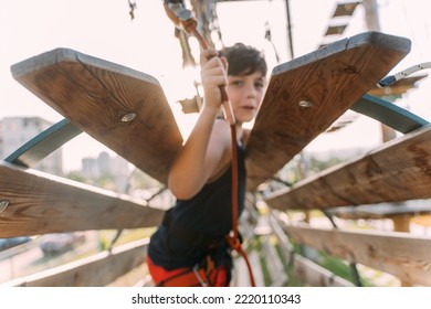 Close up of little boy on the wooden cirlce at the adventure park, blured