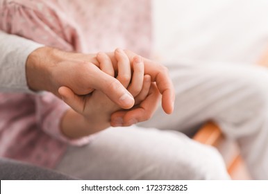 Close up of little daughter holding daddy hand, home background, family concept