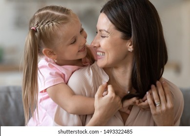 Close Up Little Daughter Hug Mom From Behind Enjoy Time Together At Home, Loving Caress 30s Mother Give Piggyback To Preschool Child Girl Looking At Each Other Feeling Love And Deep Connection Concept