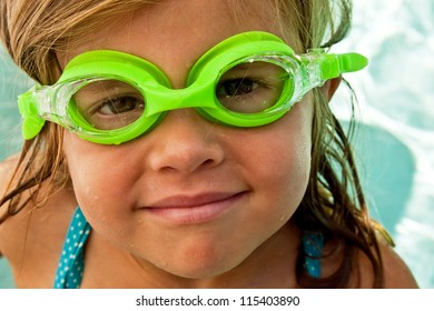 Close up of a little girl with bright green swimming goggles