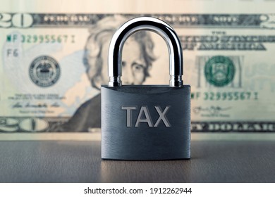 Close Up Of Lock With TAX Text On Money Background. Locked Tax Concept.