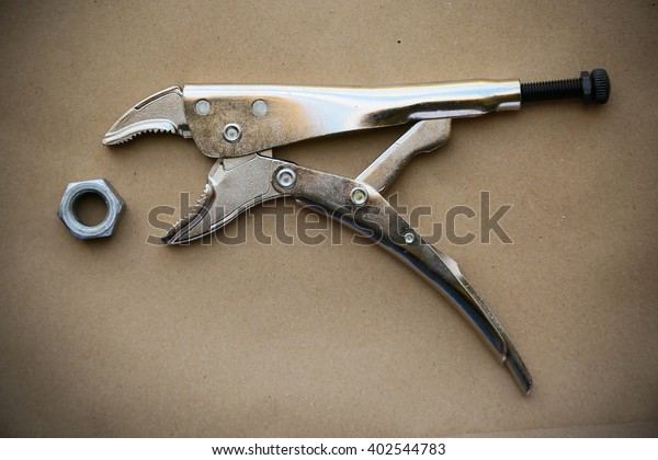 close up locking pliers on wooden background, Hand\
tools in work shop.