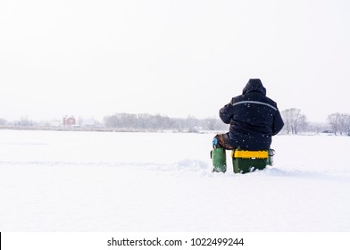 Close up Lone fisherman ice fishing on the river - Shutterstock ID 1022499244
