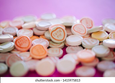 Close Up Of Love Heart Candy With Cute Sayings On Pink Background