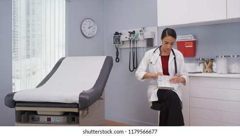 Close Up Of Lovely Latina Doctor Reviewing Patients File Indoors Medical Clinic