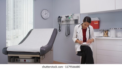 Close Up Of Lovely Latina Doctor Reviewing Patients File Indoors Medical Clinic