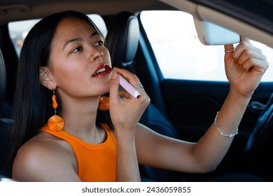 Close Up Lovely South American Woman Applying Red Lipstick Inside the Car Using The Mirror - Powered by Shutterstock