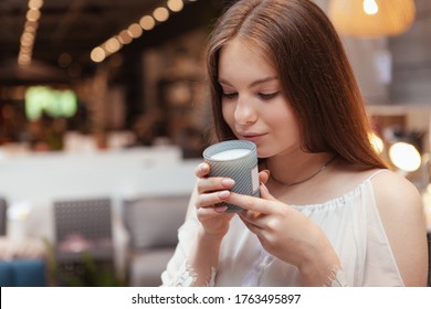 Close up of a lovely woman smelling scented candle
