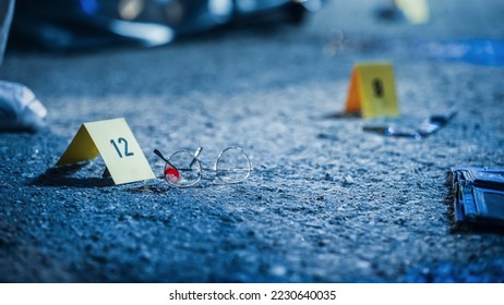 Close Up Low Angle Shot of Evidence Scattered at Crime Scene. Bloodied Glasses, Bloody Knife and Empty Wallet, all Marked as Clues in a Murder Investigation. Aesthetic True Crime Footage
