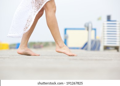 Close Up Low Angle Side View Of A Young Woman Walking Barefoot Outdoors