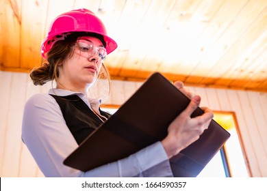 Close Up Low Angle View Of Female Home Inspector Using A Clipboard To Take Notes, Writes Review Or Report About The House Condition During Inspection