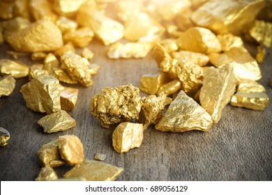 Close up lump of gold mine on wooden table - Shutterstock ID 689056129