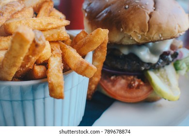 Close Up Of Luxurious Hamburger With Crispy French Fries In Fancy Setting 