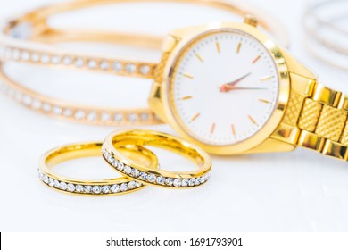 Close up Luxury gold ring and lady gold watch on white background