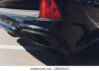 Close up of a luxury sportive car with four exhaust pipe and bumper realized in real carbon fiber.