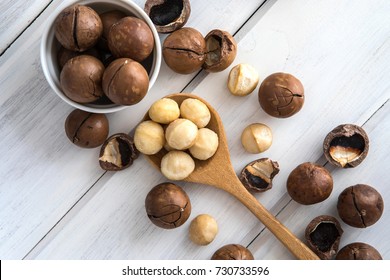 Close up Macadamia nuts on  white wooden background , superfood and healthy food concept , overhead or top view shot with vintage color tone