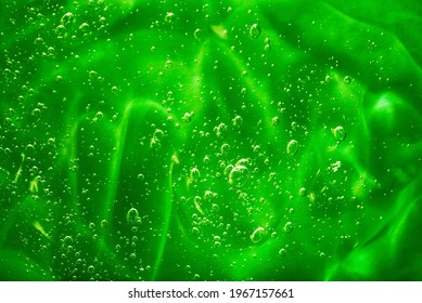 Close up macro Aloe vera gel cosmetic texture green background with bubbles. Lemongrass gel skincare product. antibacterial liquid with aloe vera, moisturizing. Cruelty free