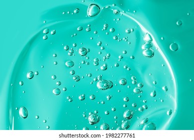 Close Up Macro Aloe Vera Gel Cosmetic Texture Blue Background With Bubbles. Lemongrass Gel Skincare Product. Antibacterial Liquid With Aloe Vera, Moisturizing. Safe And Environmental Friendly.