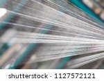 Close up macro detail of Yarn thread lines running in the weaving loom machine. Yarn bobbins making in a textile factory.