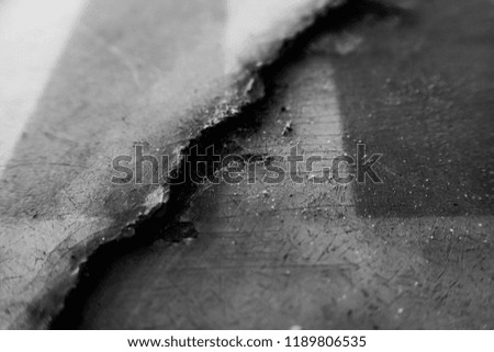 Close up macro of a large old damaged crack in a sign board.