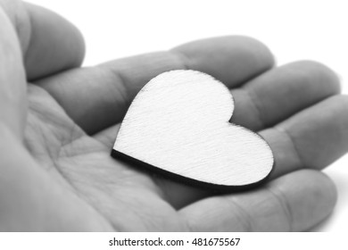 Close Up Macro Man Hand Holding Wooden Heart, Love Symbol On White Background, Black And White Effect With Selective Focus