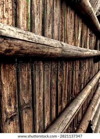 Close up macro of rustic old bamboo fence with weathered bamboo poles and slats. Dark dramatic HDR texture showing traditional rural architecture, village and natural material. Concept of bamboo, wood, fence, rustic, traditional and background.